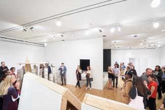 Color photograph of a crowd during a reception in a gallery.