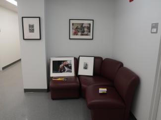 color photograph of a framed photographs resting on a red couch.